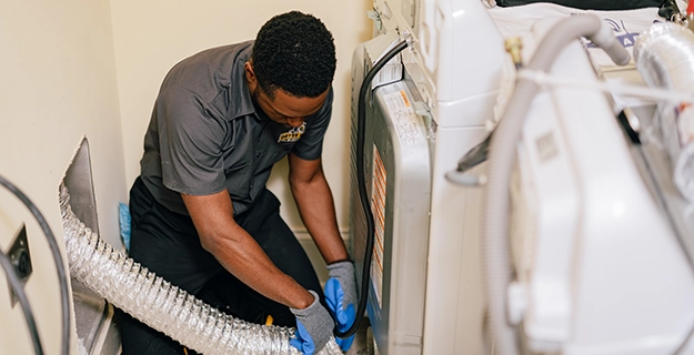 Technician removing a dryer vent air duct.