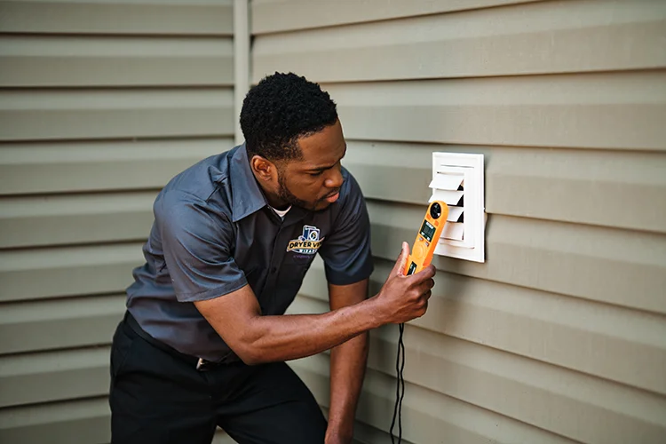 Dryer Vent Wizard tech measuring airflow during a dryer vent system inspection