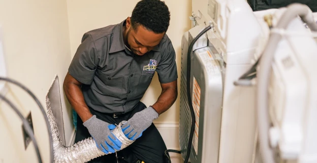 Dryer Vent Wizard technician cleaning out a dryer vent with hands.