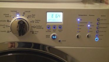 Close-up of a white dryer control panel with blue LED indicators, a cycle selection knob, and a digital display showing an E 64 error code message.